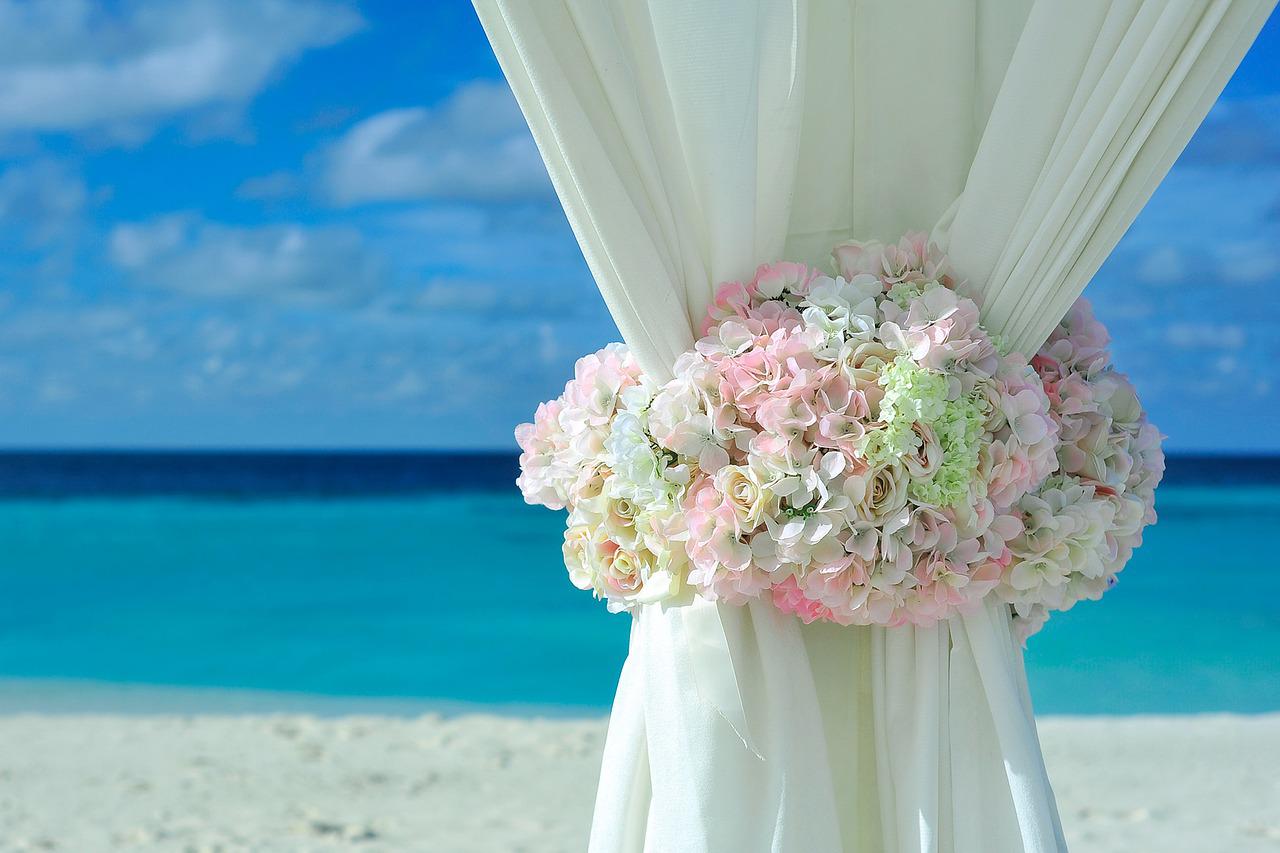 tenda bianca decorata con fiori al mare